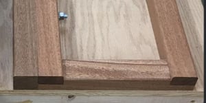 Close-up photo of a wooden piano moving board, showing detailed joinery and a bolt for securing the board.