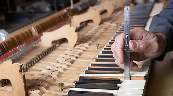 Piano technician working on piano internals